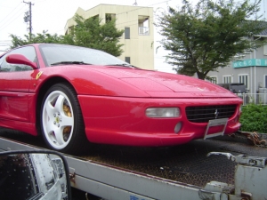 深紅に輝く積車に積まれたフェラーリ